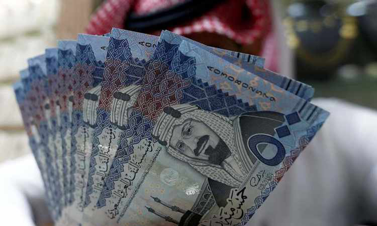 Saudi money changer displays Saudi Riyal banknotes at a currency exchange shop in Riyadh