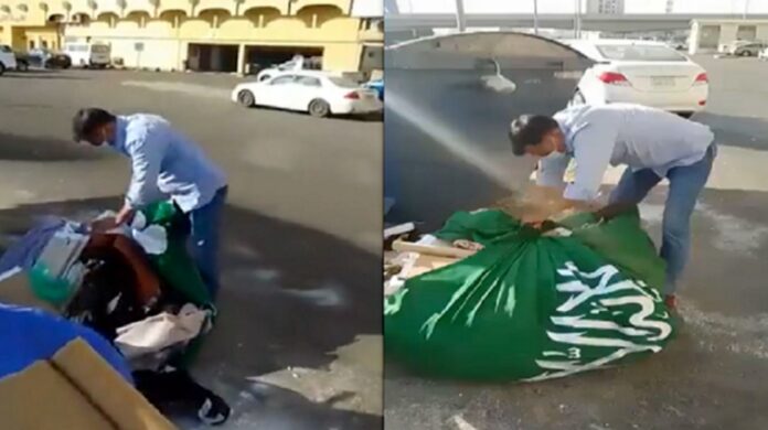 العلم السعودي تلف به الزبالة ويرمى في قمامة